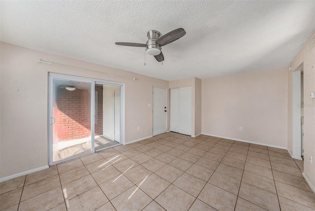 tiled empty room featuring ceiling fan and a textured ceiling