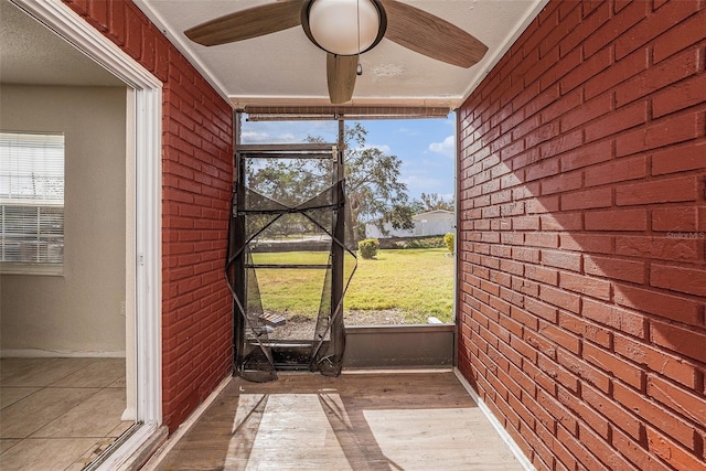 unfurnished sunroom featuring ceiling fan