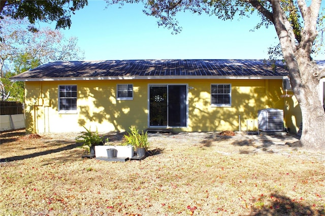 back of house featuring a lawn and central AC