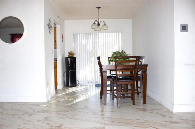 12663 Eddington Rd, Spring Hill, FL 34609 - dining area with light marble finish flooring, a chandelier, and baseboards
