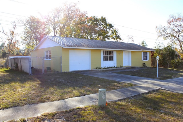 12663 Eddington Rd, Spring Hill, FL 34609 - ranch-style home with driveway, an attached garage, a gate, and metal roof