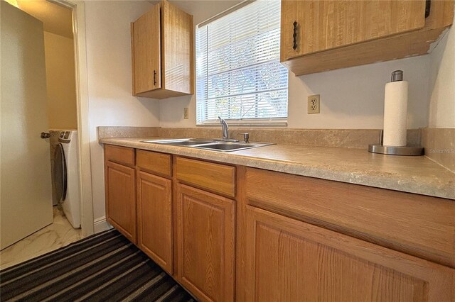 12663 Eddington Rd, Spring Hill, FL 34609 - kitchen with a sink, light countertops, dark marble finish floors, and washer / dryer