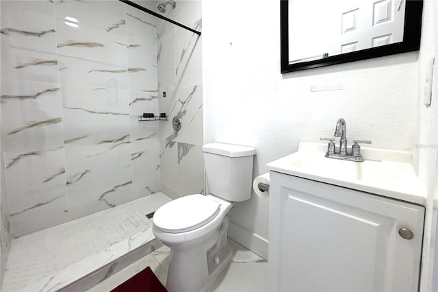 bathroom featuring toilet, vanity, and tiled shower