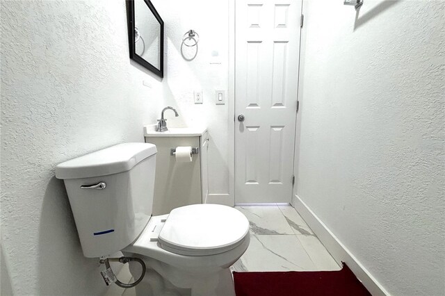 12663 Eddington Rd, Spring Hill, FL 34609 - half bathroom featuring marble look tile flooring, toilet, a textured wall, vanity, and baseboards