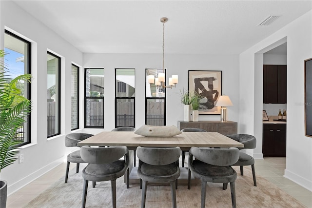 dining room featuring light tile patterned floors, baseboards, visible vents, and a notable chandelier