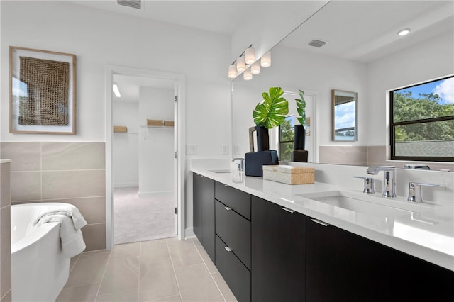 bathroom with tile patterned flooring, vanity, and tile walls