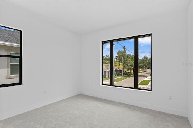 carpeted empty room featuring baseboards