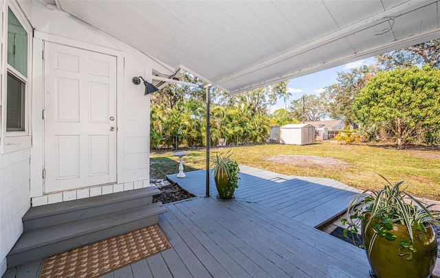 wooden deck featuring a yard and a shed