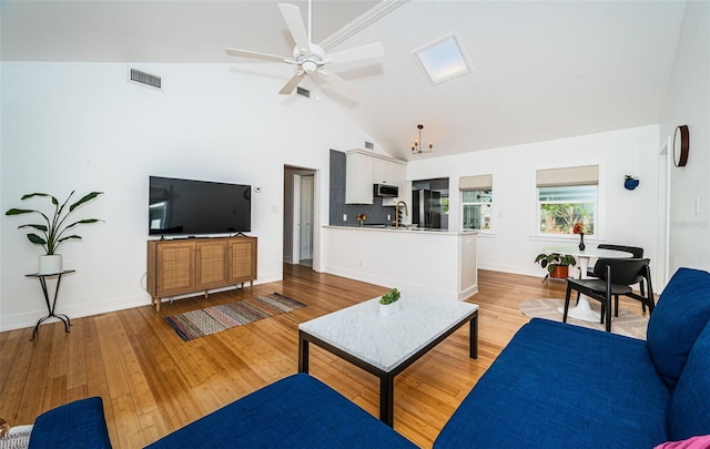 living room featuring sink, light hardwood / wood-style floors, high vaulted ceiling, and ceiling fan