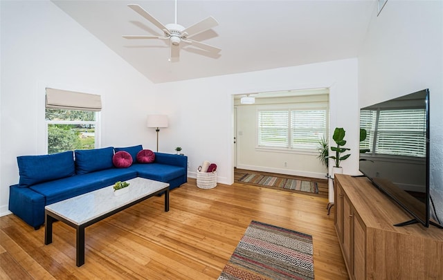 living room with ceiling fan, high vaulted ceiling, and light hardwood / wood-style flooring