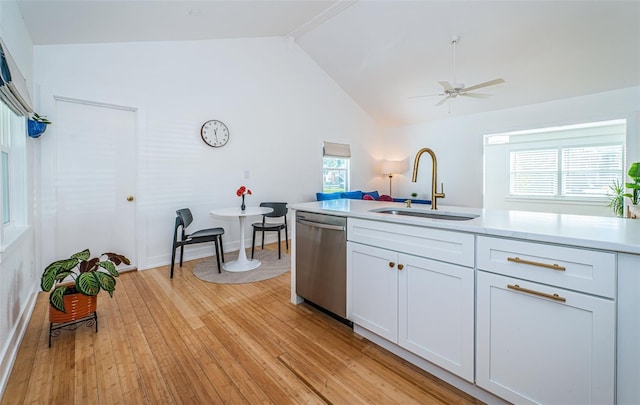 kitchen featuring dishwasher, lofted ceiling, white cabinetry, sink, and light hardwood / wood-style flooring