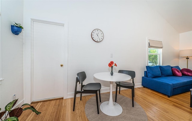 dining area featuring lofted ceiling and light wood-type flooring