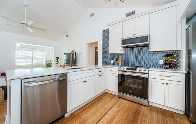 kitchen with stainless steel appliances, white cabinetry, and kitchen peninsula