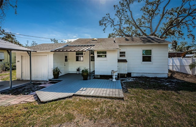 rear view of house with a deck and a lawn