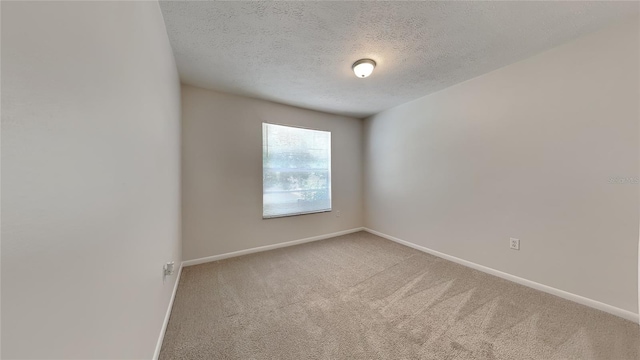 unfurnished room featuring carpet flooring and a textured ceiling