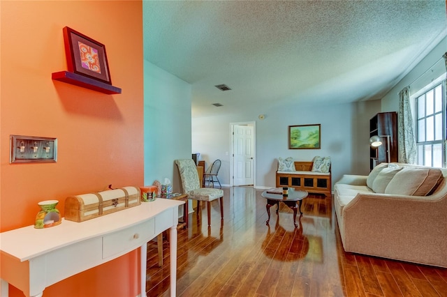 living room with hardwood / wood-style flooring and a textured ceiling