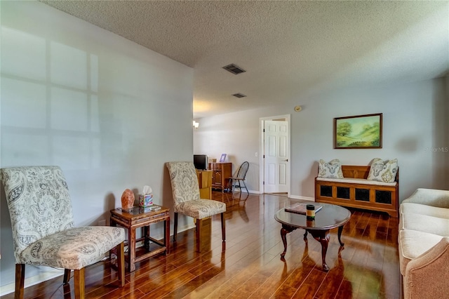 sitting room with wood-type flooring and a textured ceiling