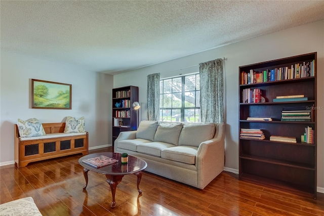 living area with wood-type flooring and a textured ceiling