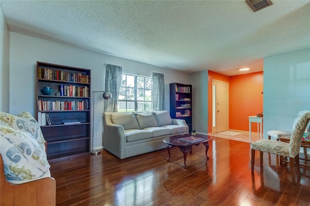 living room featuring a textured ceiling and dark hardwood / wood-style flooring