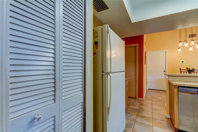 kitchen featuring wood counters, white refrigerator, dishwasher, hanging light fixtures, and light tile patterned flooring