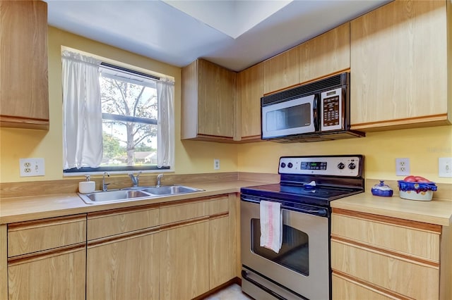 kitchen with light brown cabinets, sink, and stainless steel range with electric cooktop