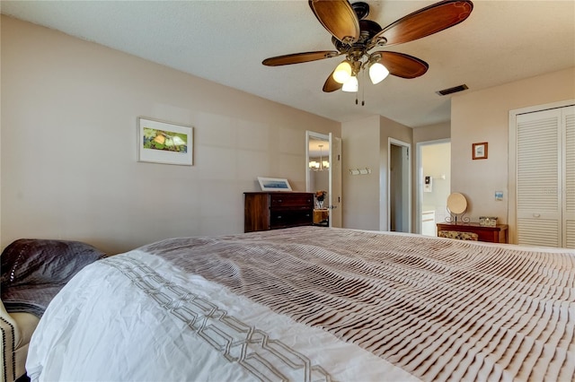 bedroom with a textured ceiling, ensuite bathroom, a closet, and ceiling fan