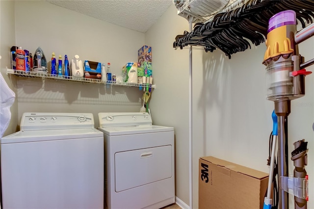 clothes washing area featuring a textured ceiling and washing machine and clothes dryer