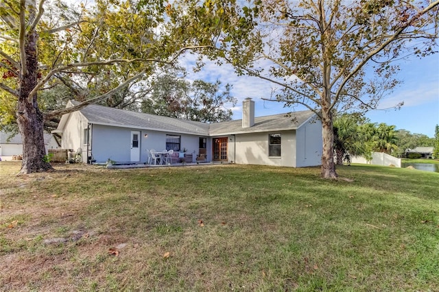 rear view of property featuring a patio area and a yard