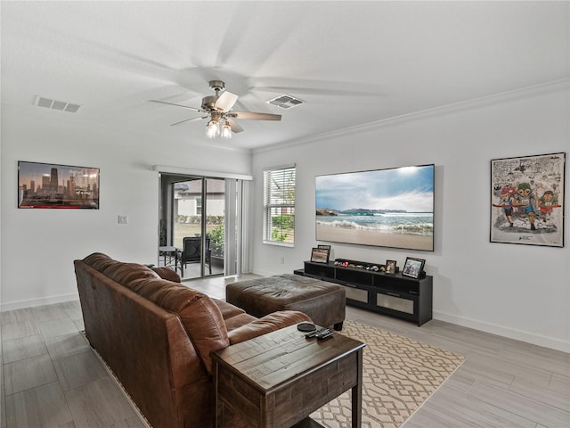 living room featuring crown molding, ceiling fan, and light wood-type flooring