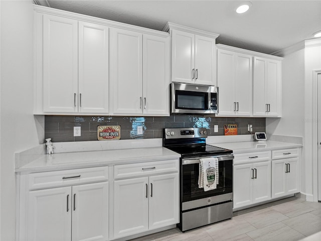 kitchen featuring backsplash, white cabinetry, crown molding, and stainless steel appliances