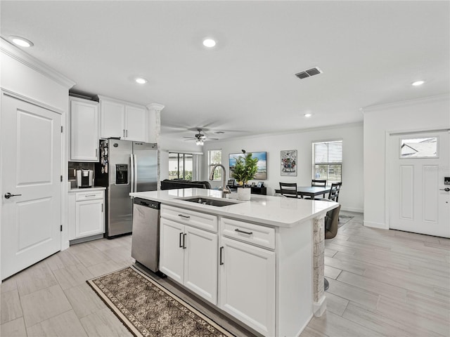 kitchen featuring white cabinetry, a center island with sink, stainless steel appliances, and sink