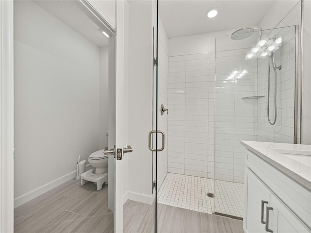 bathroom with an enclosed shower, vanity, and toilet