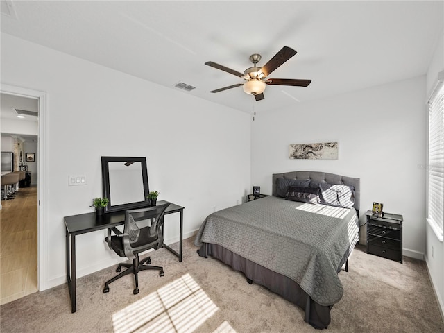 bedroom with ceiling fan and light carpet