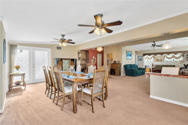 carpeted dining room with crown molding, french doors, and ceiling fan