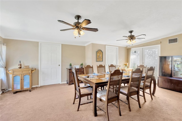 carpeted dining room with ceiling fan, french doors, and ornamental molding