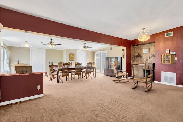 carpeted living room with ceiling fan with notable chandelier