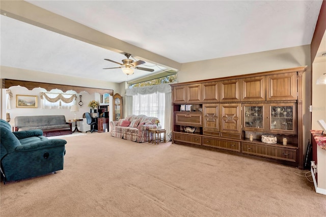 carpeted living room with vaulted ceiling with beams and ceiling fan