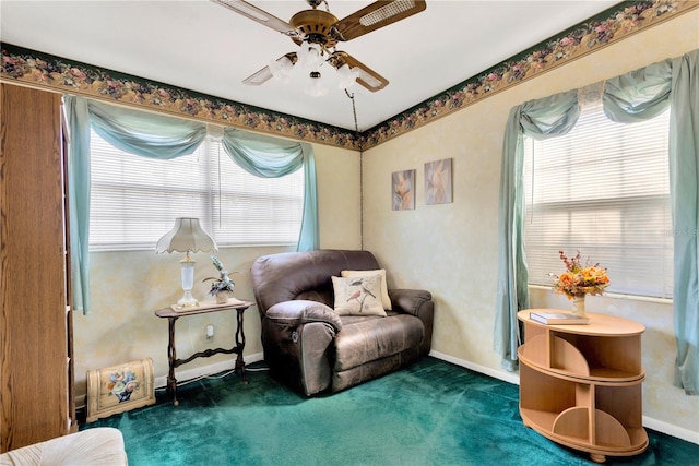 sitting room featuring dark colored carpet and ceiling fan