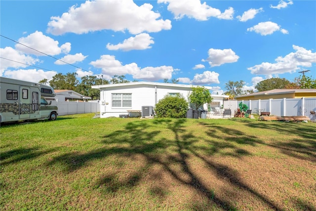 rear view of property featuring a yard and central AC