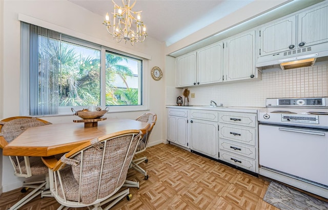 kitchen featuring stove, white cabinets, hanging light fixtures, decorative backsplash, and a chandelier