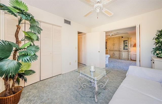 interior space featuring light carpet, a textured ceiling, and ceiling fan