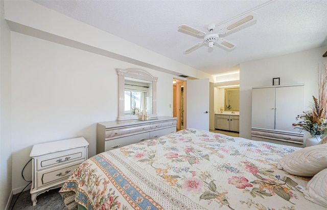 bedroom featuring connected bathroom, ceiling fan, carpet, and a textured ceiling