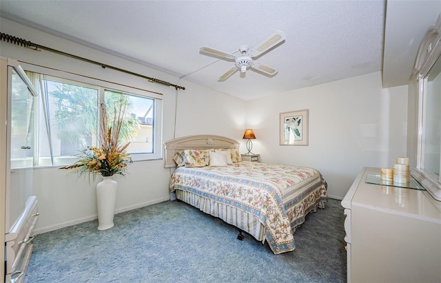 carpeted bedroom featuring ceiling fan and a textured ceiling