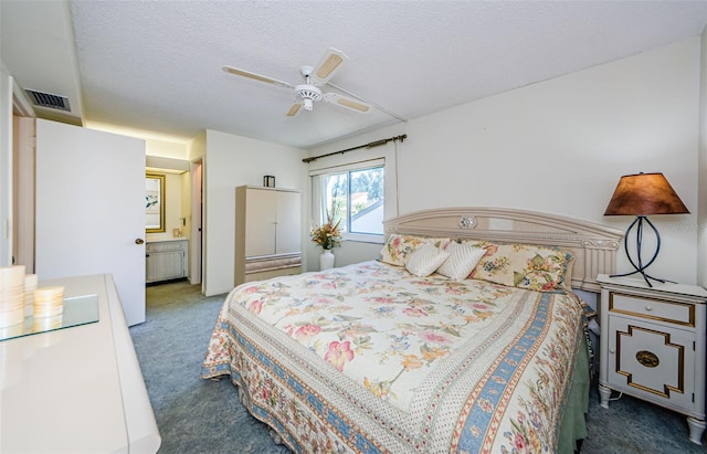 carpeted bedroom featuring a textured ceiling, ceiling fan, and ensuite bathroom