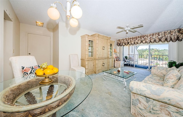 carpeted living room featuring ceiling fan with notable chandelier and a textured ceiling