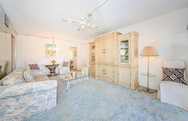 living room featuring ceiling fan, light colored carpet, and a textured ceiling