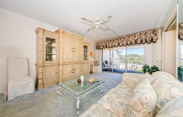 carpeted living room with a textured ceiling and ceiling fan