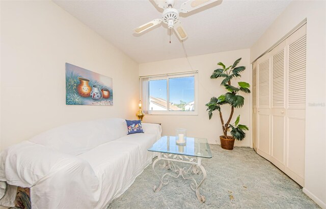 living room with a textured ceiling and ceiling fan