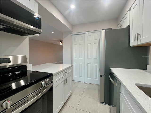 kitchen with white cabinetry, ceiling fan, stainless steel appliances, light stone counters, and light tile patterned floors