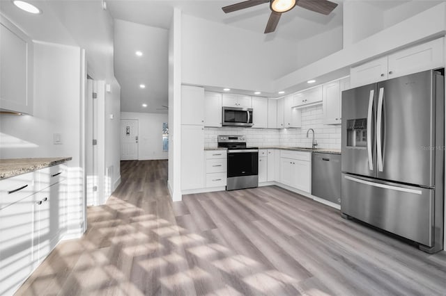 2292 Austrian Ln Unit 34, Clearwater, FL 33763 - kitchen with stainless steel appliances, light stone countertops, a sink, ceiling fan, and white cabinets